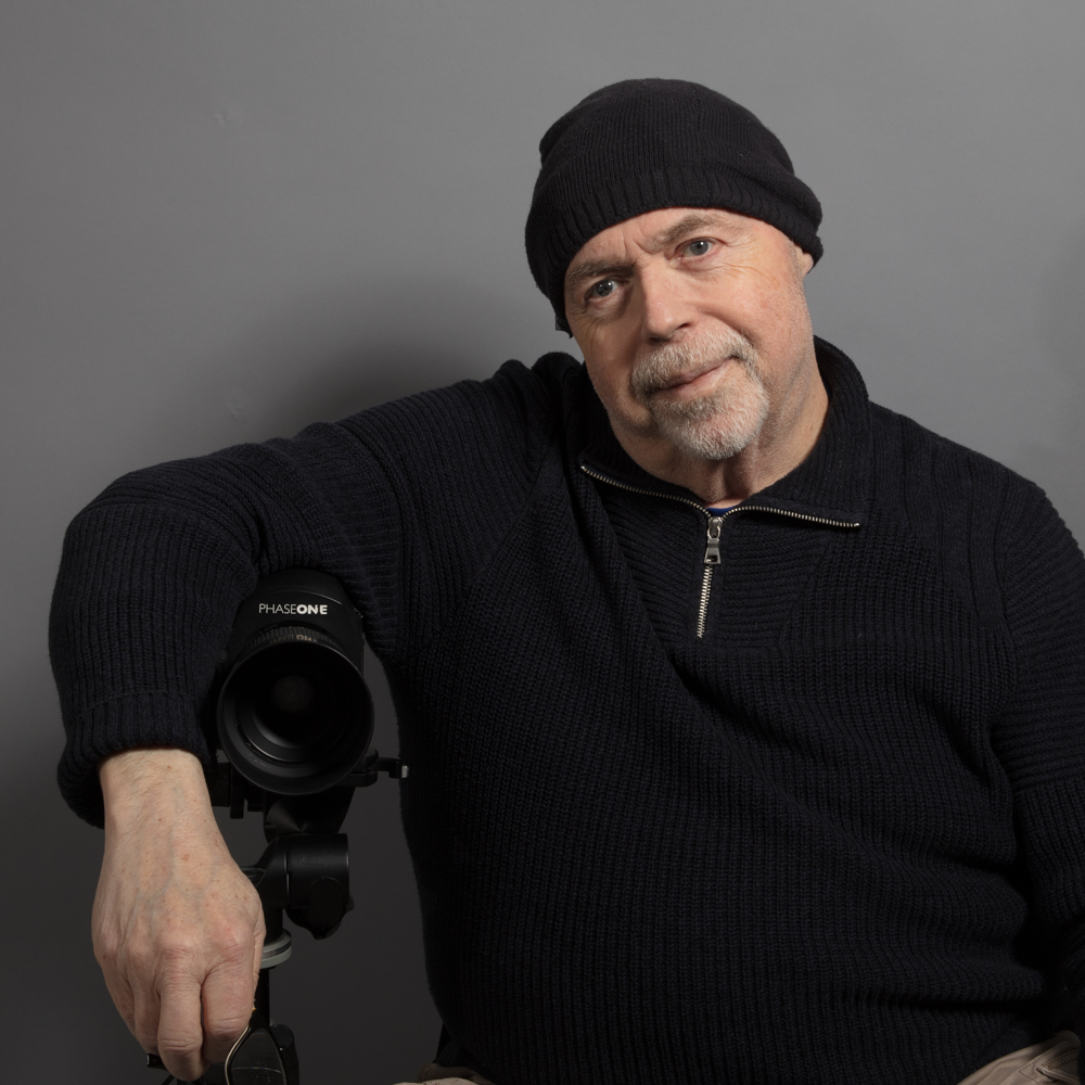photo of jim skowyra gently leaning on a phase one digital camera